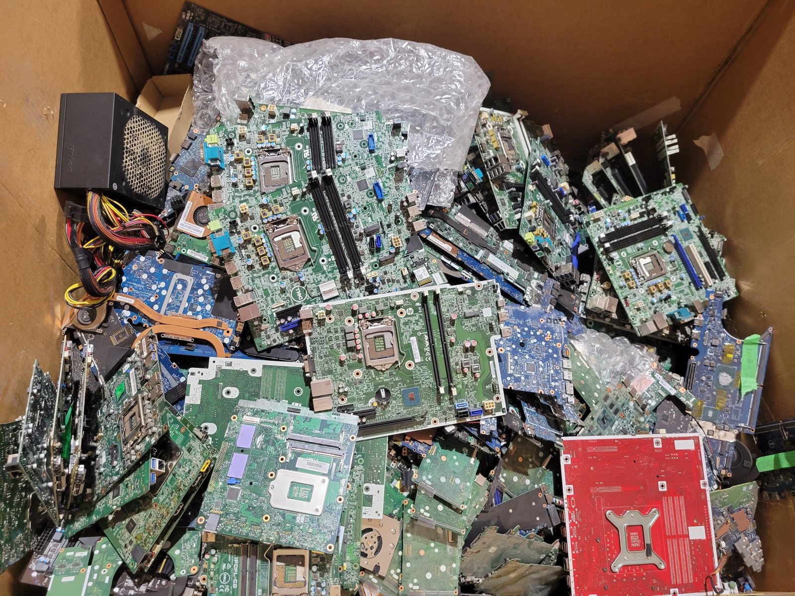 Box of recovered computer motherboards and circuit boards prepared for commodity recovery